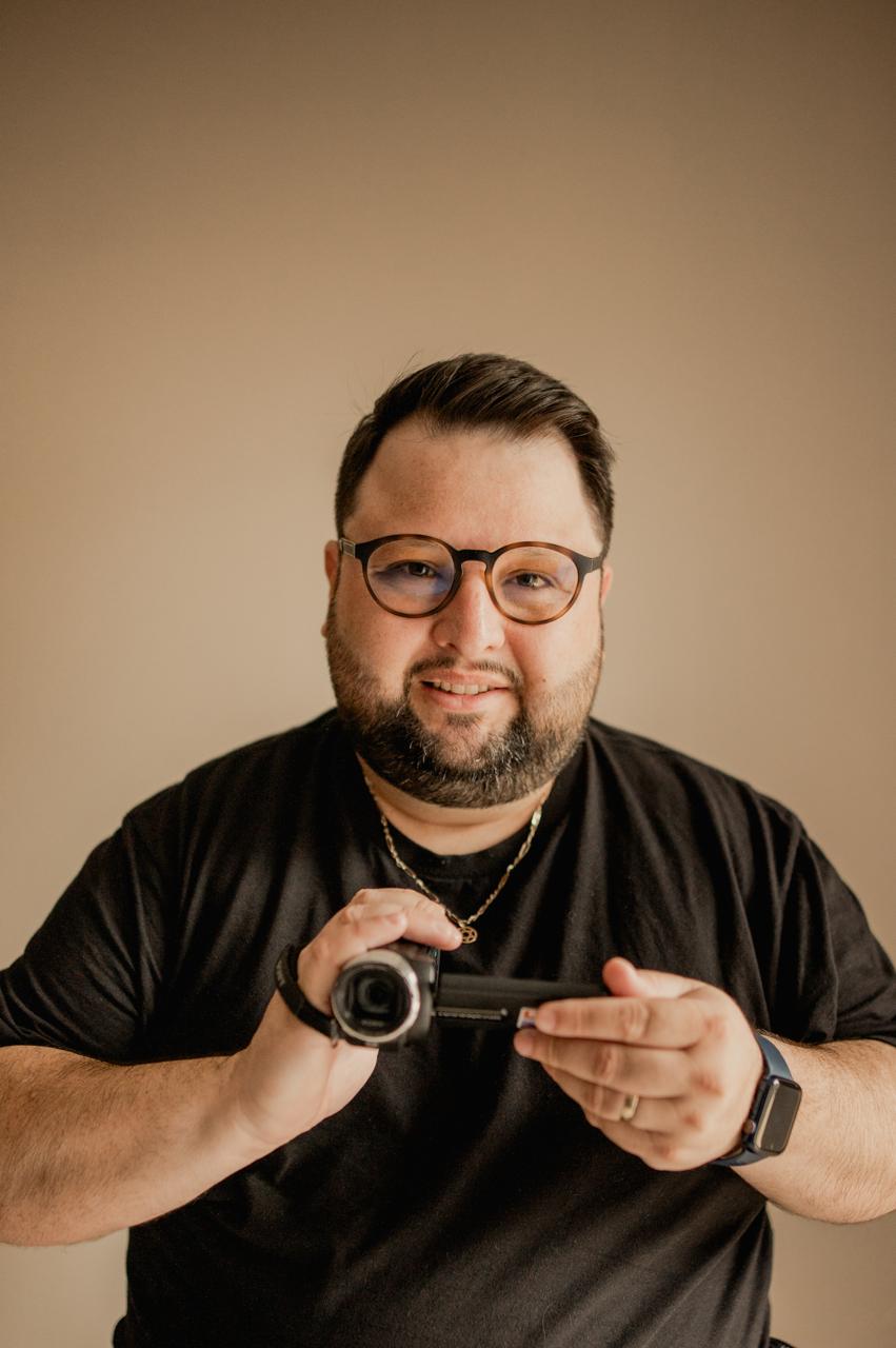Júnior Ribeiro segurando uma câmera